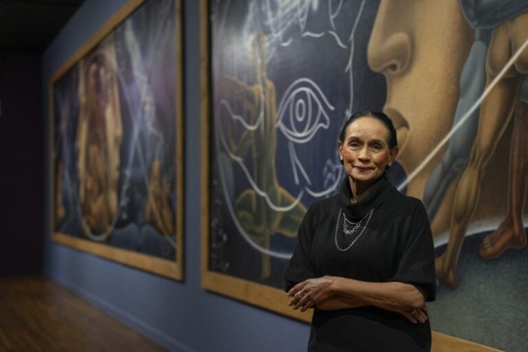 Sylvia Orozco standing in front of a large scale mural inside the Mexic Arte Museum 2024 photo by Raul Rodriguez 1200x800